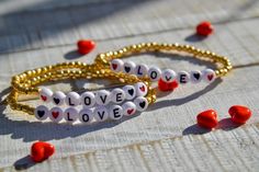 These little bracelets are dainty and a perfect little addition to any bracelet collection.  Each is composed of pretty galvanized gold seed beads and pretty, acrylic letter and heart beads that say LOVE.  Be Mine in separate listing: https://www.etsy.com/listing/1164681817/dainty-gold-seed-beaded-bracelet-with-be?click_key=1d1951875da351756aefaf5a9bc62d10ba533108%3A1164681817&click_sum=e78f509b&ref=shop_home_active_2&sts=1 Very fun on their own and to stack with other pieces and perfect for Val Valentine's Day Heart Charm Bracelet With Letter Beads, Valentine's Day Heart-shaped Charm Bracelet With Letter Beads, Friendship Letter Bead Charm Bracelet For Valentine's Day, Valentine's Day Heart Bracelet With Letter Beads For Friendship, Heart-shaped Valentine's Day Charm Bracelet With Letter Beads, Cute Gold Beaded Bracelets With Heart Beads, Valentine's Day Gold Friendship Bracelets With Letter Beads, Gold Friendship Bracelets With Letter Beads For Valentine's Day, Gold Name Bracelet With Heart Beads For Friendship