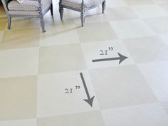 two chairs sitting on top of a checkered floor next to an arrow pointing in the opposite direction