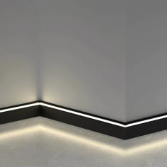 an empty room with white walls and black trimmings on the corner, illuminated by neon lights