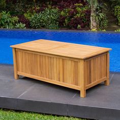 a large wooden box sitting on top of a cement slab next to a swimming pool