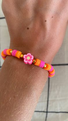 A pink and orange bracelet with a pink and orange flower charm in the middle of it. The size is 6 inches but you can order a special size for 2 dollars more. This product is durable I always make sure my products are stretchy and durable before shipping it off. Pink Flower Beaded Bracelets For Summer, Playful Pink Flower Bracelets, Orange Flower Jewelry For Beach, Orange Flower-shaped Jewelry For Beach, Cute Pink Beaded Bracelet With Flower Charm, Orange Flower-shaped Beach Jewelry, Pink Flower Charm Jewelry For Beach, Pink Flower-shaped Stretch Bracelet Gift, Pink Flower Stretch Bracelet Gift