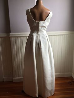 "Simply elegant white gown designed by Harry Keiser, I believe to be in the late 50's early 60's. Size 10 ( vintage 1960's sizing). Would make a lovely alternative wedding dress or formal for a 'black and white' affair. The simplicity of this dress makes it a show stopper with its square cut neckline. Totally lined with a net crinoline underneath. I believe at one time it might have had an added waist band as there are snaps and hook and eye placements in the front. I personally saw it with a wi Floor-length Evening Dress For Wedding With Pleated Back, Spring Wedding Maxi Dress With Boned Bodice, Floor-length Pleated Back Evening Dress For Wedding, Floor-length Wedding Evening Dress With Pleated Back, White Full Length Prom Dress, Vintage White Evening Dress For Wedding, Vintage White Wedding Evening Dress, White Evening Dress With Boned Bodice, Classic White Evening Gown