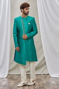 Teal green overlap sherwani with floral placement embroidery and mandarin collar. Paired with churidar.
Component: 2
Pattern: Embroidered
Neckline: Mandarin
Sleeve Type: Full Sleeves
Fabric: Art Banarasi Silk, Dupion Art Silk
Color: Green
Other Details: 
Front buttons
Note: Pocket square worn by the model is not for sale
Occasion: Wedding - Aza Fashions Placement Embroidery, Embroidered Neckline, Green Art, Churidar, Full Sleeves, Embroidered Silk, Fabric Art, Teal Green, Mandarin Collar