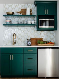 a kitchen with green cabinets and white tile backsplashing, stainless steel dishwasher