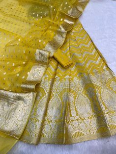 It's a beautiful lehenga set of chanderi material . The whole collection has beautiful pastel and few bright shades .  Lehenga - 5 Mtr Banarasi Matt zari lorex fabric. Blouse - 1 mtr lorex matt zari Dupatta - 2.5 mtr matt lorex fancy weaving  Dry clean only . Please note - color may be vary a little due to sunlight and photography . This is unstitched material only . Lehenga and blouse stitching is also available . Elegant Yellow Dola Silk Anarkali Set, Unstitched Anarkali Cotton Silk Lehenga, Gold Cotton Silk Designer Wear Sets, Yellow Cotton Silk Sets With Zari Work, Yellow Cotton Silk Anarkali Set For Wedding, Designer Gold Cotton Silk Sets, Gold Cotton Silk Designer Sets, Gold Semi-stitched Anarkali Set In Cotton Silk, Festive Sheer Dupatta Cotton Silk Lehenga