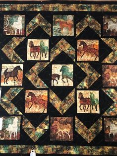 a quilted wall hanging with horses on it's sides and squares in the middle