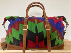 Our Handmade Bohemian Kilim Leather Travel Bag is a top pick for eco-conscious shoppers and sustainable lifestyle advocates. The roomy interior and durable construction make it a reliable choice for weekend getaways and outdoor adventures, while the multicolor woven design and leather accents make it a stylish accessory for fashion-conscious nomads and rustic explorers.Looking for a versatile statement piece? Our Handmade Vintage Kilim Leather Multicolor Bag is the perfect pick for creative indi Handmade Brown Travel Bag, Handmade Satchel Weekender Bag For Travel, Luxury Multicolor Satchel For Travel, Bohemian Rectangular Duffle Bag With Leather Handles, Bohemian Brown Duffle Bag With Leather Handles, Brown Bohemian Duffle Bag With Leather Handles, Handmade Rectangular Weekender Bag For Travel, Bohemian Brown Bags For Weekend Trips, Bohemian Brown Weekender Bag With Leather Handles