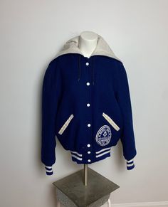 "Vintage 1970s zipper hood wool varsity jacket. Such a fun hood/collar. Embroidered Sarah on the collar. Fun patch on the front pocket. Love the blue and white. Simple classic preppy jacket. Tagged size 38, fits like a S. Width : 20 1/2\" Length 23\"" Hooded Varsity Jacket, Fall Varsity Hoodie For School, Blue College Style Outerwear For School, Collegiate Cotton Hooded Outerwear, Collegiate Style Cotton Hooded Outerwear, Varsity Hooded Jacket For College In Fall, Hooded Cotton Varsity Jacket For College, Hooded Cotton Varsity Jacket, Hooded Cotton Varsity Jacket For School