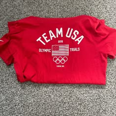 a red team usa shirt laying on the floor