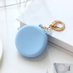 a blue round keychain sitting on top of a white table next to a plate