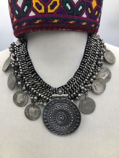 *This oxidized silver coin necklace is a divine piece of the tribe of Kuchi. Drooping silver bells with coins augment the glamour of this elegant necklace. This necklace is bold and attractive. This vintage necklace is handcrafted by outstanding craftsmen. Made up of the best quality material this necklace is one of the stunning necklaces in our collection. *The necklace consists of nine semi silver coins from which the one in the center is the eye-catchy one. The details and design of this neck Bohemian Coin Necklace In Metal, Bohemian Coin Metal Necklace, Vintage Silver Coin Necklace For Festivals, Bohemian Coin-shaped Metal Necklace, Bohemian Metal Necklaces With Coin Pendant, Festival Medallion Necklace With Coin Pendant, Bohemian Metal Necklace With Coin Pendant, Festival Coin Pendant Medallion Necklace, Handmade Bohemian Coin Medallion Necklace