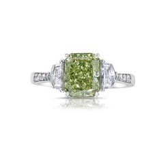 Our new line of diamonds with flavors of green in them set in a ring with green painted enamel under the diamond to make it appear as a pure green diamond. The diamond is 100% natural and GIA certified, but the ring is colored underneath the stone to enhance the green color. Extremely lively and gorgeous green color 100% eye clean Set in 18kt Gold with 0.31ct of step cut trapezoids and 0.13ct of round diamonds Luxury Lime Green Elegant Rings, Luxury Gold Emerald Ring With Diamond Accents, Green Radiant Cut Diamond Ring, Green Radiant Cut Diamond Ring Fine Jewelry, Fine Jewelry Green Radiant Cut Diamond Ring, Fine Jewelry Green Emerald Ring With Single Cut Diamonds, Green Diamond Cut Diamond Ring, Luxury Green Diamond Ring With Brilliant Cut, Green Radiant Cut Ring With Center Stone