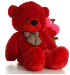 a red teddy bear sitting in front of a chair