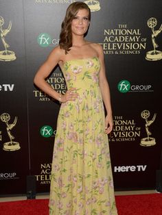 a woman in a yellow dress on the red carpet at an awards event with her hands on her hips