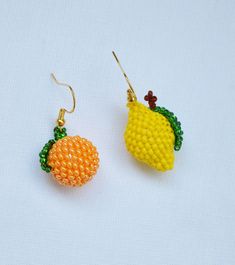 the earrings are made out of beads and have fruit on them, as if they were beaded