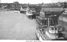 an old black and white photo of boats in the water near buildings on either side