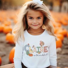 Long Sleeve Toddler Thanksgiving Shirt for boys or girls. A delightful and personalized garment that will bring extra joy to your child's Christmas. This charming Thanksgiving t-shirt displays your child "is thankful," capturing the essence of the thanksgiving season. But what makes it truly special is the adorable turkey, pumpkins and falling leaves that surround your child's name. Each t-shirt is personally and uniquely designed. It's a whimsical scene that will ignite the imagination and fill Personalized Cotton T-shirt For Fall, Casual Personalized T-shirt For Fall, Personalized Casual T-shirt For Fall, Customizable Cute Tops For Fall, Cute Name Print Tops For Fall, Cute Tops With Name Print For Fall, Toddler Thanksgiving Shirt, Doodle Name, Toddler Thanksgiving