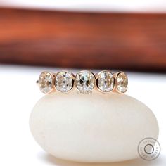 three stone ring sitting on top of a white rock