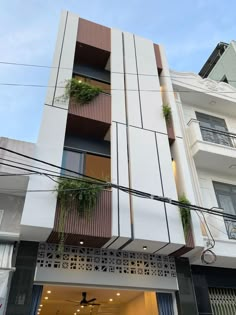 an apartment building with plants growing on the balconies