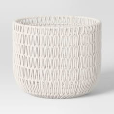 a white basket that is sitting on the ground