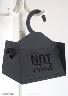 a black paper bag hanging from a white hook