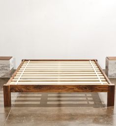 a wooden bed frame sitting on top of a tiled floor