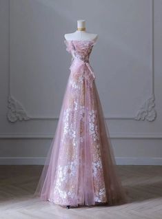 Qaudrangular elegance meets modern design in this enchanting prom dress, crafted to make you feel like a fairy-tale princess. The soft pink hue, complemented by delicate floral embroidery and shimmering details, creates a look that is both romantic and sophisticated. The off-shoulder neckline enhances the gown's ethereal appeal, while the fitted bodice and flowing skirt provide a flattering silhouette. The tulle overlay adds a touch of whimsy, ensuring you make a grand entrance. Perfect for those who want to combine contemporary flair with timeless beauty, this dress promises to make your prom night unforgettable. Celebrate your unique style and grace with this stunning gown that captures the essence of elegance and charm. Make your special night truly magical with this exquisite dress. Stunning Prom Dress, Iconic Prom Dresses, Ethereal Prom Dress, Pink Fairy Dress, Cheap Long Dresses, Fairy Prom Dress, Plus Size Prom Dress, Strapless Prom Dress, Stunning Prom Dresses