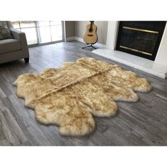 a living room with a couch, chair and rug on the floor in front of a fireplace