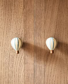 two white and blue hot air balloons are on the wall in front of a wood paneled door