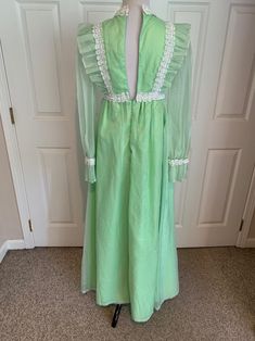 This nice vintage 1970's Mint green & white Swiss Dot and Lace Pinafore dress comes to you in a size small. The dress is a high waist style fully lined-has sheer sleeves and giant ruffle at bottom with lace trim-Has the Pinafore Front-In great vintage cond-Pls compare the measurements I give you to those in your closet-They are as follows- -14 3/4 to 15 inches shoulder to shoulder -25 1/2 inches shoulder to bottom of sleeve -waist is 14 inches across -hips N/A -49 inches underarm to bottom o Green Vintage Ruffled Dress For Spring, Green Retro Vintage Dress, Green Vintage Dress For Summer, Green Vintage Style Dress For Summer, Green Summer Dresses For Vintage Fashion, Green Summer Dresses In Vintage Style, Green Summer Dress For Vintage Fashion, Summer Green Vintage Dress With Ruffles, Vintage Long Sleeve Green Dress