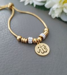 Sparkling Gold Allah Bracelet, Religious Islamic Muslim Jewelry, Quality Stainless Steel Adjustable, Gift for Her, Arabic Women Gifts Delicate and sparkling bracelet featuring Allah name pendant. Adult size adjustable bracelet 18k gold plated All metal parts are stainless steel, It's safe for the skin and won't tarnish or rust over time Gold Charm Bracelet With Adjustable Length As Gift, Gold Charm Bracelet With Adjustable Length, Gold Bracelets With Adjustable Length For Gift, Gold Bracelets With Adjustable Length As Gift, Gold-tone Stainless Steel Chain Bracelet For Gifts, Gold Bracelet With Adjustable Length As Gift, Adjustable Gold Stainless Steel Bracelet, Adjustable Gold Stainless Steel Jewelry, Adjustable Gold-plated Name Bracelet