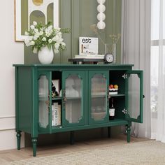 a green sideboard with glass doors in a living room