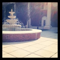 a water fountain in front of a brick building