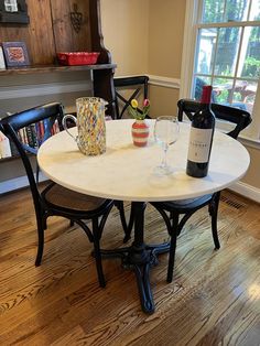 a table with two wine glasses on it and a bottle of wine in the middle