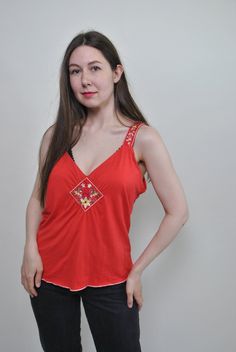 Check out this floral red tank top made of mixed synthetic fabric with flowers embroidery. Good choice for summer festival outfit. Great relaxed top for hippie vibe. Welcome to TARASCOMMON.ETSY.COM Unique clothing from the 20th century. Model tall - 170cm. Size: M. Width - 46cm / 18.11inch; Length - 60cm / 23.62inch. All measurements are taken seam to seam while lying flat. Viscose/ Elastan. This item is vintage, so it can have some defects. Additional photos can be send We are glad that you are Summer Hippie V-neck Top, Vintage Sleeveless Tops For Summer, Red Sleeveless Top With Floral Embroidery, Red Sleeveless Tops With Floral Embroidery, Sleeveless Red Tops With Floral Embroidery, Orange V-neck Top For Festivals, Hippie Style Summer Festival Tank Top, Summer Festival Hippie Tank Top, Spring Red Camisole For Beach