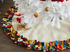 a white christmas tree skirt with colorful streamers