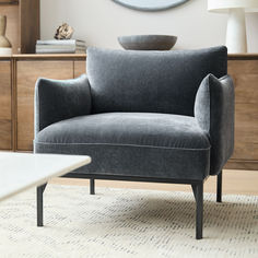 a gray chair sitting on top of a white rug