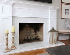 a living room with a fireplace and two candles