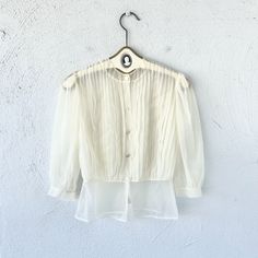 "S p e c i f i c s . . . Label: Paulwin Tagged Size: -- Approx Fit: XS - S Color: White Material: Nylone Sheer Material // Buttons  Condition: Overall in Amazing Vintage Condition M e a s u r e m e n t s . . . (side to side // laying flat // closed) Bust - approx. up to 21\" Waist - approx. 14\" Length - approx. 22\"" Summer Button-up Top With Sheer Sleeves, Chic Vintage Spring Tops, Chic Fitted Tops For Vintage Fashion, Vintage Spring Party Shirt, Chic Vintage Summer Tops, Elegant Vintage Summer Tops, Spring Vintage Button-up Tops, Vintage Sheer Blouse For Spring, Vintage Sheer Blouse For Parties