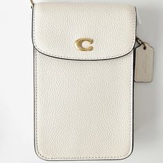 Coach Phone Crossbody Bag Color: Brass/Chalk Product Details Materials : Polished Pebble Leather Fabric Lining Strap : Detachable Strap With 21.5" Drop For Shoulder Or Crossbody Wear Features : Outside Open Pocket Two Credit Card Slots Snap Closure Measurements : Length: 4.5" Height: 7.25" Width: 1.0" Fits All Phone Sizes Up To An Iphone X And Samsung S7 Edge Comes From A Non-Smoking Home. Please Note That The Measurements Of The Item Will Be Approximate Sizes. Color Of The Item Might Be Slightl White Rectangular Shoulder Bag With Cell Phone Pocket, White Rectangular Phone Bag With Removable Pouch, White Phone Shoulder Bag With Cell Phone Pocket, White Shoulder Bag With Mobile Phone Pocket For On-the-go, White Shoulder Phone Bag With Cell Phone Pocket, White Phone Bag With Cell Phone Pocket, White Shoulder Phone Bag With Cell Pocket, White Luxury Shoulder Bag With Mobile Phone Holder, On-the-go White Shoulder Bag For Mobile Phone