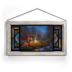 a stained glass window hanging on the wall above a fire pit with lights in it