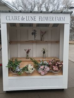 a flower shop with flowers on display in front of the store's sign that says clarie de lune flower farm