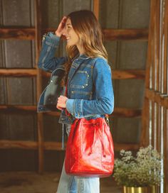 Everything and the kitchen sink (ok, not quite) can fit inside EVE.  EVE is a new bucket-style bag with a drawstring cinch top, wide flat bottom, and an adjustable and removable crossbody strap.  As tall as she is cute, EVE has a cool football topstitch effect up the front seams.  Inside find a zip pocket, two slip pockets and a key FOB.  Roomy and great for errands, EVE is the timeless silhouette youve been looking for. Leather Tote Shoulder Bag For Weekend, Casual Fall Tote Bucket Bag, Casual Fall Bucket Tote Bag, Casual Red Bags For Weekend, Casual Red Bags For The Weekend, Casual Red Bag For Weekend, Casual Red Weekend Bag, Fall Adjustable Strap Crossbody Bucket Bag, Crossbody Bucket Bag With Pockets