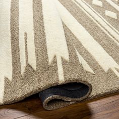 a close up of a rug on the floor with a black shoe laying underneath it