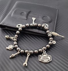 These cute and classy custom Beaded Car Part Charm Bracelets are trendy and will surely make a statement! Create a unique bracelet that shows off your unique style! This bracelet can fit up to 15 charms. Charm Options: - Option#1: Fully Custom Bracelet (Plain Bracelet/ No Charms) Please order your charms for this option here: Charm Listing - Option#2: 15 Random Charms - Option#3: Driver’s Bracelet Turbo, Car Keys & Remote, Steering Wheel, Gear, Stoplight, Wrench, Mini Racecar - Option#4: Mechanic’s Special Wrench, Crescent Wrench, Hex Nut, Spark Plug, Heart Gear, Piston, Screwdriver - Option#5: Track Edition Racing Seat, Turbo, Racing Flag, Wheel / Tire, Mini Racecar, Stoplight, Wrench - Option#6: Rotary Lover Rotary, Steering Wheel, Car Keys & Remote, Mini Racecar, Gear, Wrench, Hex Nut T Metal Beaded Charm Bracelet Gift, Metal Beaded Stretch Bracelet As A Gift, Novelty Metal Bracelet Jewelry, Nickel Free Novelty Bracelet Jewelry, Metal Stretch Bracelet With Round Beads For Gift, Trendy Metal Beaded Bracelets With Charms, Novelty Charms Bracelet Jewelry, Novelty Jewelry Charms Bracelet, Metal Jubilee Stretch Bracelet Gift