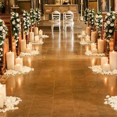 an aisle decorated with white flowers and candles