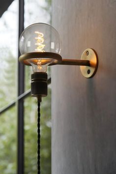 a light that is on the side of a wall next to a glass door and window