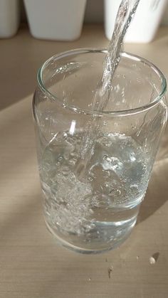 a glass filled with water on top of a table