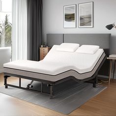 a bed that is sitting on top of a rug in a room next to a window