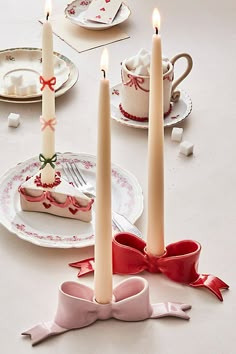 a table topped with plates covered in cake and candles